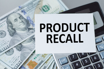 Product Recall text on a card that is on a calculator on an office desk