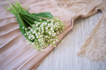 delicate lace dress and a bouquet of lilies of the valley. dry cleaning clothes, freshness concept