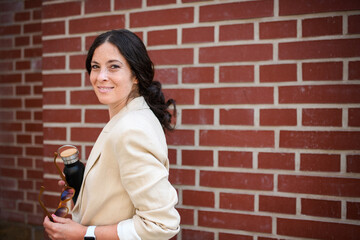 Woman walking going to work, holding water bottle. Successful happy businesswoman commuting in the...