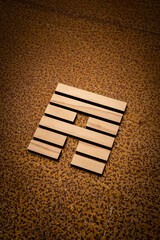 wooden Gene Key 53 i ging hexagram on rusty metal background human design