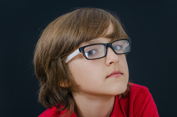 Teenager in red t-shirt and glasses looking at camera