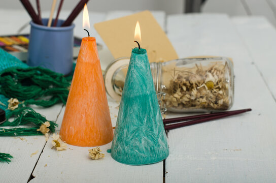 Two burning candles with dry herbs