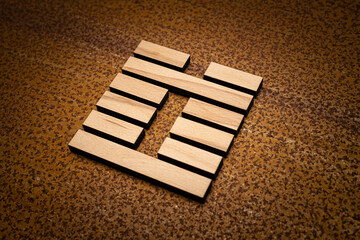 wooden Gene Key 3 i ging hexagram on rusty metal background human design