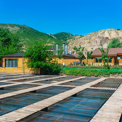 fish farm in a mountain valley with aquaculture cages and wooden buildings