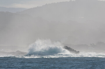 Rough seas off the californian coast breaking their waves against the steep cliffs.