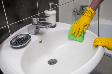 Man cleaning sink in hotel room close up