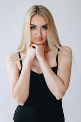 Close-up portrait of a waist-length girl with Blond hair and expressive Eye Make-up against a white wall
