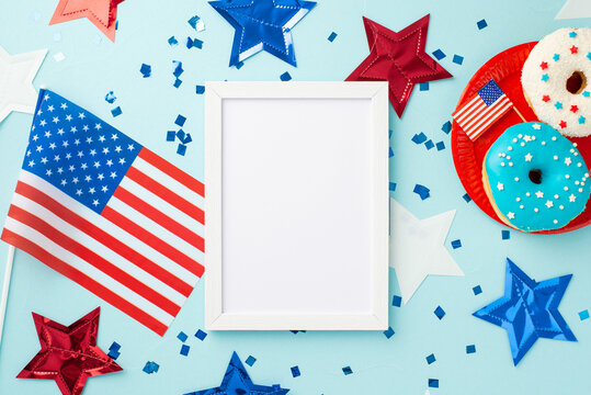 USA Independence Day concept. Top view photo of photo frame star garland national flags confetti and plate with glazed donuts on isolated pastel blue background with empty space