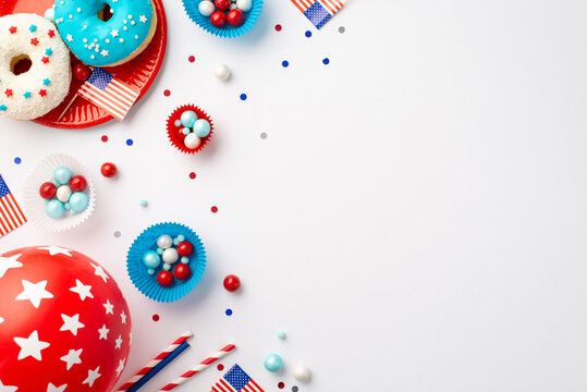 USA Independence Day concept. Top view photo of national flags balloon confetti paper baking molds with candies candles straws and plate with glazed donuts on isolated white background with copyspace