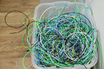 Tangled, disorganized and several strands of light, with different colors, in a plastic box.