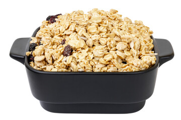 Dry muesli in a black plate. Muesli isolate.