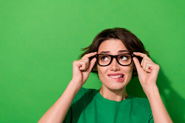 Photo of doubtful funny lady wear spring outfit arms spectacles looking empty space isolated green color background