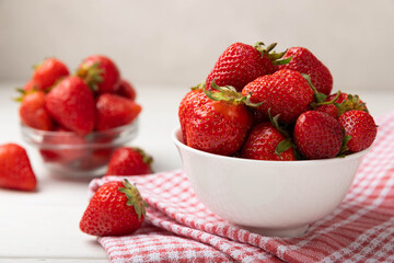 Fresh ripe juicy strawberries in a bowl on a white wooden table. Summer background composition with strawberries. Fruit concept.Vitamins.Eco berries. Copy space
