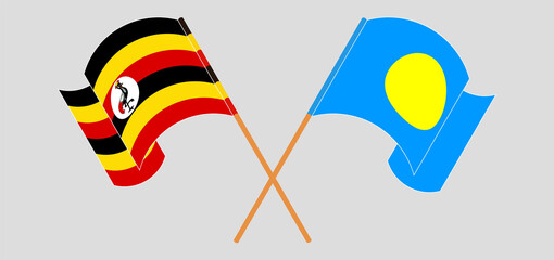 Crossed and waving flags of Uganda and Palau