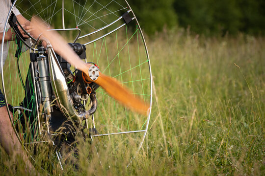 The pilot is preparing a paralet with a gasoline engine for flights. The man is warming up the engine. Motorized equipment for individual paragliding flights. Extreme sports.
