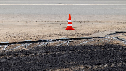 Repair of the roadway is fenced off with a construction cone