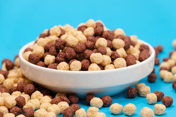 Corn sweet balls on a blue background with place for text. Quick dry breakfasts, side view.