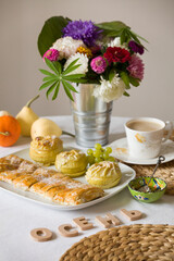Top view of a plate with homemade crispy apple pie, with baked apples with a cup of coffee and flowers. The inscription in Russian - autumn. Homemade baking. Healthy food concept.