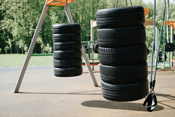 Sports ground in park outdoors. Rubber car tires for street training boxing, workout © Sergio