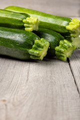 Fresh organic zucchini squashes on wooden background.