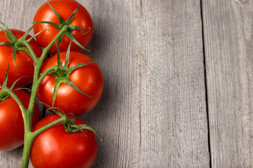 Fresh red ripe tomato on wooden background. Top view. Copy space.
