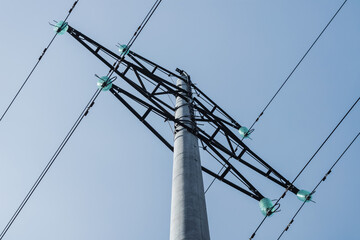 High-voltage tower with concrete base and glass insulators.
