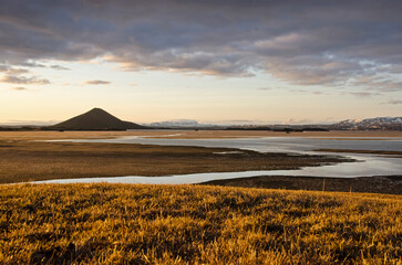 Skútustaðir, Iceland, April 27, 2022: view from a grassy hill towards lake Myvatn, partly covered...