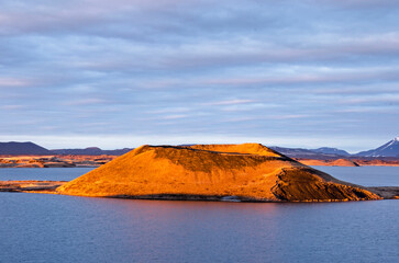 Skútustaðir, Iceland, April 27, 2022: one of the pseudocraters at the southern shore of lake Myvatn, illuminated by warm sunlight during the golden hour