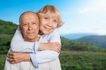 Fototapeta premium Portrait of an affectionate mature couple sitting on a pier out on a lake background