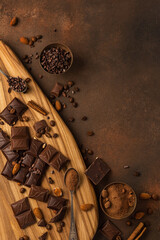 Different chocolate on a wooden board on a brown background