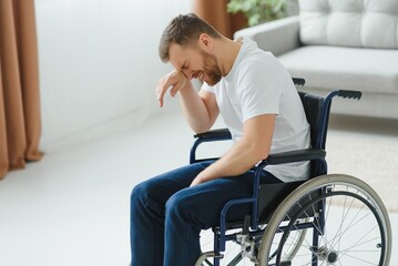 Depression and loneliness in disabled man. Elderly man in wheelchair crying indoors.