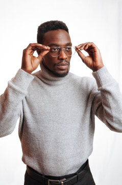 Serious thoughtful black man adjusting his glasses isolated on white studio background, an african man sees better with glasses