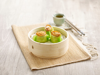 Steamed Prawn Dumpling with Abalone served in a wooden bowl with chopsticks isolated on mat side view on grey marble background