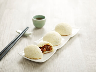 Baked BBQ Honey Pork Bun served in a tray with chopsticks isolated on mat side view on grey marble background