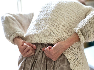 腰を両手でたたく高齢女性