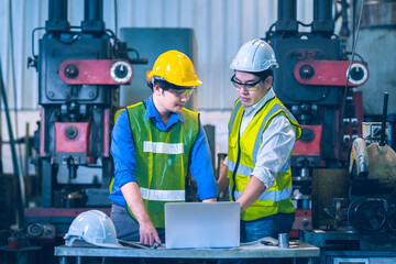 The worker teammate engineer white and yellow safety helmet working together and discussing and white helmet order to teammate as follow instruction on tablet