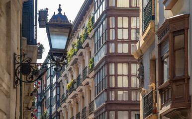 Fasada zabytkowego  budynku , w tle ulica , na pierwszym planie latarnia. Bilbao - obrazy, fototapety, plakaty