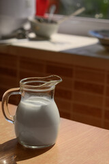 A jug of milk on a rustic table.