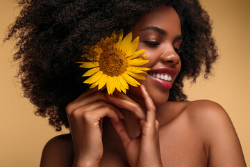 Black woman putting sunflower into hair