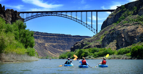Kayaking on River in Canyon with Bridge Spaning Distance
