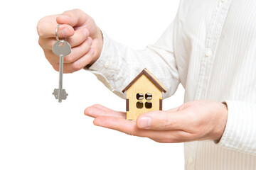 Man holding toy house and a house key in hands