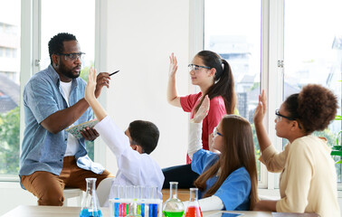 group of male and female students Studying with an African science teacher in an interactive discussion class