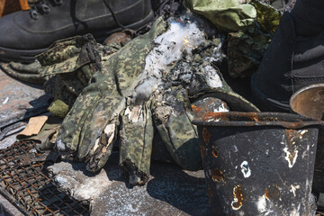 The war in Ukraine, the soldier's personal belongings, a burnt glove lie on the burnt equipment
