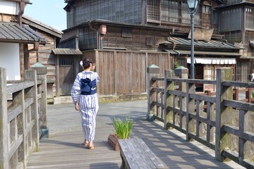 小江戸佐原の町並みを歩く浴衣を着た若い女性の後ろ姿	