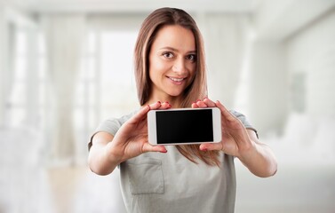 Enthusiastic young woman with a smartphone, showing advertisement on mobile phone