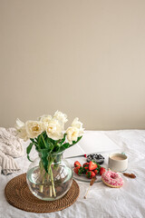 Cozy composition with a bouquet of tulips and a cup of coffee.