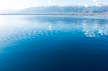 Clear water texture in blue and orange. Background of the ocean and the sea backlit by the sun. Natural water