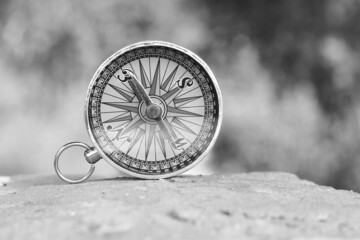 Classic navigation compass on natural background as symbol of tourism with compass, travel with...
