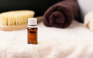   Eco cosmetic concept. Essential oil  dark bottle, Spa towel, body brush, copy space. Beauty procedures products.