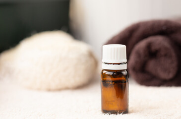 ESSENTIAL OIL in dark bottle , white towel, body brush, copy space, spa procedures products, eco cosmetic